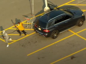 A man in an orange shirt gives chase after a failed carjacking attempt at Trinity Common Mall in Brampton on Sept. 16, 2020.