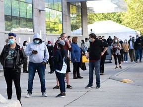 Hundreds of people wait in line for hours at a COVID assessment centre at Women’s College Hospital during the COVID-19 pandemic in Toronto on Wednesday, September 23, 2020.