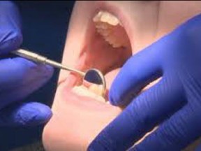 A dentist checks a patient's teeth.