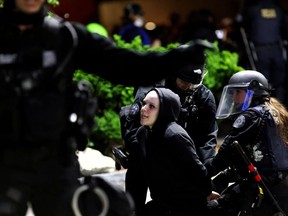 Police officers detain a demonstrator after clashes broke out outside the Portland Police Bureau building, as protesters demonstrate against police violence and systemic inequality for the 99th consecutive night, in Portland, Oregon, U.S. September 4, 2020.