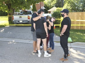 Friends showed up with flowers and and broke down in tears out front of a home on Parklane Ave., in Oshawa., where five people were found shot to death on Friday, Sept. 4, 2020.