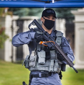 A York Regional Police officer hold a seized AR-15 rifle during a news conference in front of a mansion at 5 Decourcy Ct., near Major Mackenzie Blvd. and Warden Ave., in Markham, Ont. on Wednesday September 30, 2020. The mansion was allegedly being used as an illegal gaming house and was shut down as a part of Project End Game.