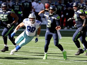 Russell Wilson  of the Seattle Seahawks looks to pass against the Dallas Cowboys during the second quarter in the game at CenturyLink Field on September 27, 2020 in Seattle, Washington.