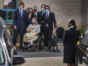 Loretta Traynor watches from a wheelchair as four caskets are loaded onto the hearses after a funeral mass for her husband Christopher Traynor and three of their children -- Bradley, 20, Adelaide 15 and Joseph, 11 -- at St. Mary of the People Catholic Church in Oshawa, Ont. on Thursday, Sept. 17, 2020.