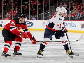 Alex Ovechkin #8 of the Washington Capitals takes the puck as Joey Anderson #49 of the New Jersey Devils defends in the third period at Prudential Center on March 19, 2019 in Newark, New Jersey.