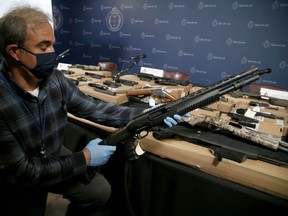 Special Const. Ed Costa with some of the 31 firearms seized during a multi-jurisdictional police investigation -- dubbed Project Sunder -- that targeted the Eglinton West Crips street gang at Toronto Police Headquarters on Thursday, Oct. 29, 2020.