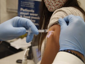 Shoppers Drug Mart pharmacist Abdeen Salim Hamid administers a flu shot on Oct. 19, 2020 at the Coxwell and Danforth Aves. location.