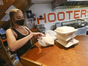 While takeout is still allowed, new COVID rules imposed last week shut restaurants and bars for 28 days. Here, Erin -- who works at a Hooters restaurant on Adelaide  and John Sts. -- is pictured while preparing a take-ouit order on Oct. 9, 2020.