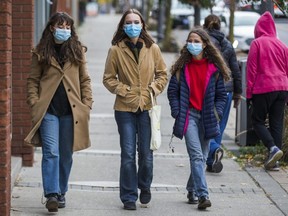 Wearing their masks, Donna (from left), Jane and Angel walk along Main St. E. in downtown Milton, Ont. on Oct. 25, 2020. Milton is one of the communities in Halton Region which could be targeted with COVID restrictions on Monday.