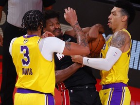 Anthony Davis (left) and Danny Green of the Los Angeles Lakers defend Jimmy Butler of the Miami Heat during the fourth quarter in Game 4 of the 2020 NBA Finals on Oct. 6, 2020, in Lake Buena Vista, Fla.