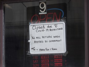 A sign in a barber shop window indicated the establishment was closed because of COVID-19 in Ottawa, Wednesday, March 18, 2020.