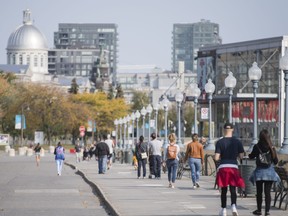 People walk along the promenade in the Old Port area of Montreal, Saturday, Oct. 10, 2020.