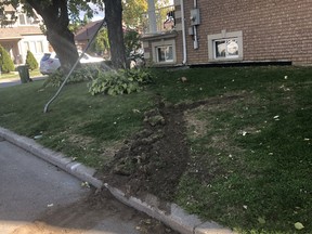 Tracks can be seen on a lawn where a car came to rest after a shooting left a driver dead late Wednesday, Oct. 8, 2020 at Khedive and Regina Aves., just west of Bathurst St.