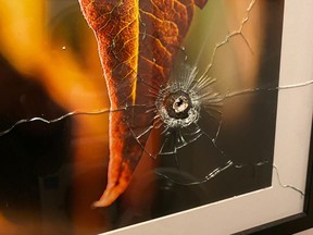 An image posted to Twitter by Lucas Timmons of damage to a photo after a bullet from a short-term rental unit next door entered his downtown condo Oct. 13, 2020.