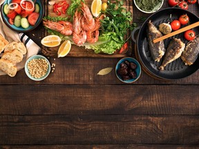 Family dinner table with shrimp, fish grilled, salad, different snacks with border