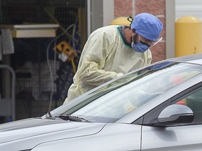 A medical professional makes an assessment at the COVID-19 assessment centre at Carling Heights Optimist Community Centre in London, Ont. on Monday, October 12, 2020.