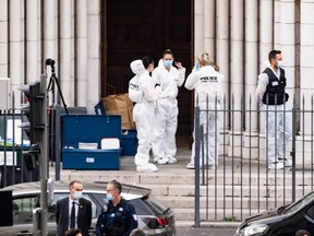 A forensic team stands in front of the Notre-Dame church in Nice, France, after a man armed with a knife fatally attacked people inside the church, Thursday, on Oct. 29, 2020.
