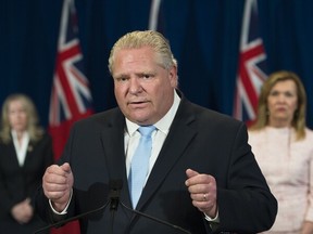 Ontario Premier Doug Ford answers questions on long-term-care homes at Queen's Park in Toronto May 26, 2020 as Minister of Long-Term Care Merrilee Fullerton, left, and Health Minister Christine Elliott listen.