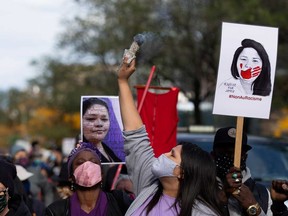 A woman smudges during a march to demand justice and raise awareness for Joyce Echaquan, an indigenous woman, who recently died while subjected to insults, at a Quebec hospital, in Montreal, Oct. 3, 2020.