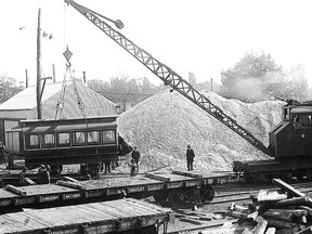 At the newly established Toronto Transportation Commission’s Coxwell storage yard one of the 85 old and now useless wooden streetcars is seen being loaded on a railway flat car for shipment to Haileybury where it and others would find new uses as shops and houses. October 10, 1922.