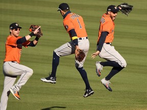 Houston Astros’ George Springer (4)m Carlos Correa (1) and Josh Reddick (22) celebrate after the Astros defeated the Oakland Athletics in Game 2 of the 2020 ALDS at Dodger Stadium in Los Angeles on Oct. 6, 2020. Robert Hanashiro/USA TODAY Sports