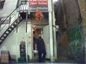 A screengrab from dashcam video shows a Mamma's Pizza employee throwing a pan of sauce onto the windshield of an illegally parked vehicle at the back of the shop on Yonge St. in north Toronto.