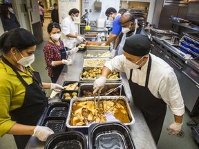 Staff prepare Thanksgiving meals in the kitchen of the Scott Mission in Toronto, Ont. on Monday October 12, 2020.