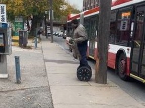 A man is seen helping a raccoon from going into a busy roadway and then hopping on his Segway and carrying the animal to safety in a video posted to Reddit.