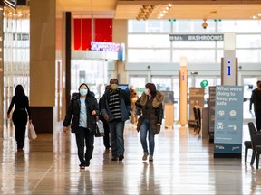 People walks inside Yorkdale Shopping Centre as the city enters the first day of a renewed coronavirus lockdown due to a spike in cases in Toronto, Nov. 23, 2020.