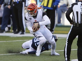 Bengals quarterback Joe Burrow breaks a tackle against Titans defensive back Chris Jackson yesterday. Burrow led the Bengals to an upset win over the Titans.