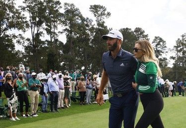 Dustin Johnson of the U.S. celebrates with partner Paulina Gretzky as he walks off the 18th green after winning The Masters.