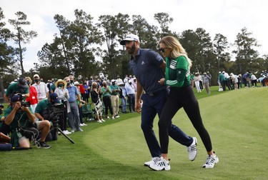 Dustin Johnson of the U.S. celebrates with partner Paulina Gretzky as he walks off the 18th green after winning The Masters.