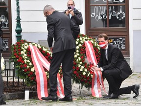 Austrian Chancellor Sebastian Kurz (R) and Austrian President Alexander van der Bellen pay their respects to the victims of a shooting in Vienna on November 3, 2020, one day after the shooting at multiple locations across central Vienna.