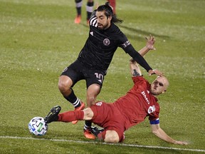 Toronto FC’s Michael Bradley (right) challenges Inter Miami’s Rodolfo Pizarro in East Hartford, Conn., last night. Toronto FC won the game 2-1