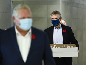 Ontario Finance Minister Rod Phillips, right, and Premier Doug Ford deliver baked goods and coffee to frontline health workers at Humber River Hospital ahead of the Ontario budget during the COVID-19 pandemic in Toronto on Thursday, November 5, 2020.
