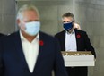 Ontario Finance Minister Rod Phillips, right, and Premier Doug Ford deliver baked goods and coffee to frontline health workers at Humber River Hospital ahead of the Ontario budget during the COVID-19 pandemic in Toronto on Thursday, November 5, 2020.