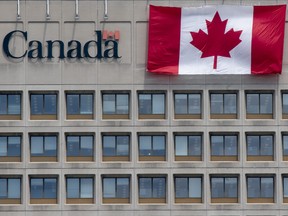 A giant Canadian flag hangs on the side of a government office building in downtown Ottawa, Tuesday, June 30, 2020. THE CANADIAN PRESS/Adrian Wyld