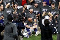 Dodgers’ Justin Turner (centre) poses for a photo with teammates after Los Angeles defeated the Tampa Bay Rays in Game 6 to win the World Series on Oct. 27 in Arlington, Texas. Turner had a positive COVID-19 test discovered mid-game.