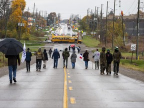 Land defender Skyler Williams of Six Nations, centre, walks with a group of labour councils and unions who delivered food and support to land defenders in Caledonia, Ont., at a land reclamation camp known as 1492 Land Back Lane on Tuesday, October 27.