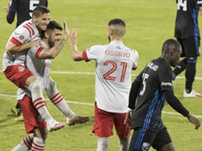 Pablo Piatti rides on the back of teammate Alejandro Pozuelo while celebrating a TFC goal with Jonathan Osorio during a game in Montreal this past summer.