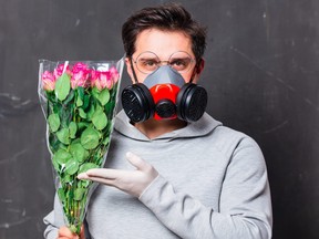 in love man in face mask holds roses bouquet