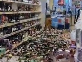 A woman smashed some 500 bottles of booze in a rampage in a British shop.