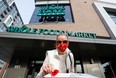 Dagmar Dohler takes a poppy that is given away in front of a Whole Foods store in Ottawa, Ontario, Canada, on Nov. 6, 2020.