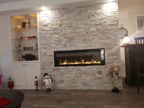 An electric fireplace (the DimplexXLF50) and stone veneer wall serve as the room's focal point. SUPPLIED