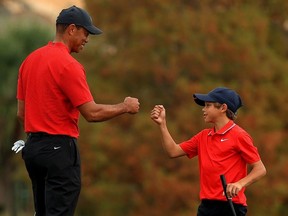 Tiger Woods of the United States and son Charlie Woods fist bump on the 18th hole during the final round of the PNC Championship at the Ritz Carlton Golf Club on December 20, 2020 in Orlando, Florida.