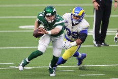 Jets QB Sam Darnold scrambles out of the pocket as Rams' Aaron Donald gives chase.