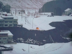 A car has stopped were the road has been swept away by a landslide in the town of Ask, Gjerdrum county, some 40 km northeast of the Norwegian capital Oslo, on Dec. 30, 2020.