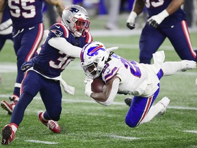 Zack Moss of the Buffalo Bills dives for yardage as Devin McCourty of the New England Patriots defends at Gillette Stadium on December 28, 2020 in Foxborough, Massachusetts.