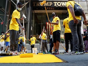 People paint "Black Lives Matter" along 5th Avenue outside Trump Tower in the Manhattan borough of New York July 9, 2020.