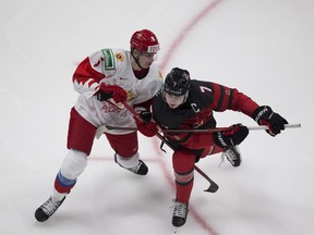 Canada's Kirby Dach (7) and Russia's Danil Chaika (5) battle for the puck  during second period IIHF world junior hockey championship pre-competition action on Wednesday, Dec. 23, 2020 in Edmonton.